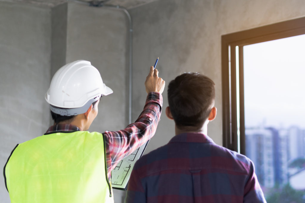 A man and woman looking at something on the wall.